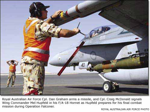 Royal Australian Air Force Cpl. Dan Graham arms a missile