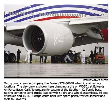 The ground crew changing a tire on a 777-300ER