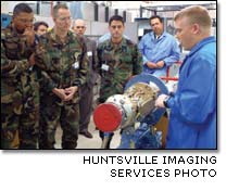 James Simpson explains an assembly process to Col. John Vaughn and members of his staff.