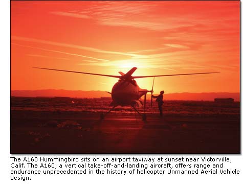 The A160 Hummingbird sits on an airport taxiway at sunset