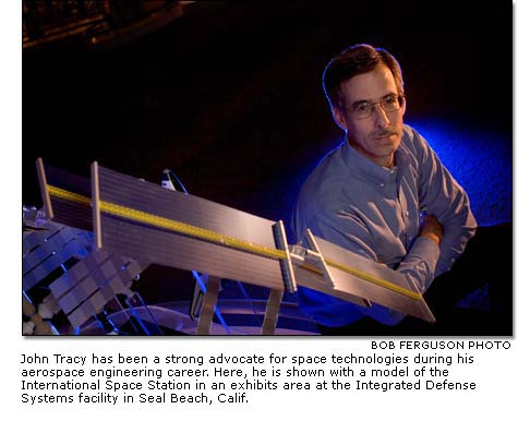 John Tracy with a model of the International Space Station