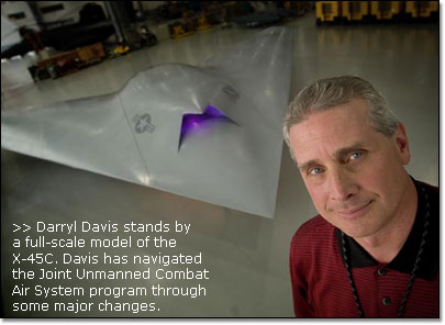 Darryl Davis stands by a full-scale model of the X-45C.