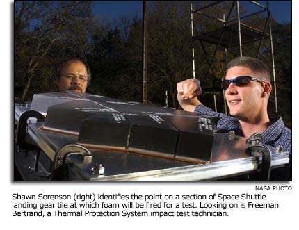 Shawn Sorenson and Freeman Bertrand looking at a section of Space Shuttle landing gear tile