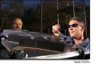 Shawn Sorenson and Freeman Bertrand looking at a section of Space Shuttle landing gear tile