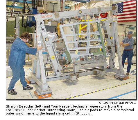 Sharon Beauclar and Tom Naeger use air pads to move a completed outer wing frame