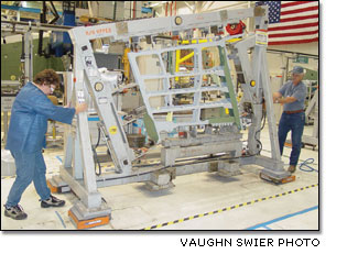 Sharon Beauclar and Tom Naeger use air pads to move a completed outer wing frame