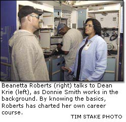 Beanetta Roberts (right) talks to Dean Krie (left), as Donnie Smith works in the  background.