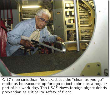 C-17 mechanic Juan Rios practices the "clean as you go" motto as he vacuums up foreign object debris