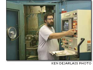 Jim Bergman runs one of the large, five-axis milling machines found in the sprawling Auburn Machining 17-07 building.