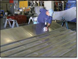 Toolmaker Walt Norton cleans a test panel for a Boeing 7E7 fuselage developed with stringers fully integrated instead of bonded on the skin. 