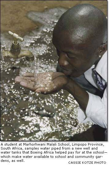 AA student at Marhorhwani Malali School, Limpopo Province, South Africa, samples water piped from a new well and water tanks