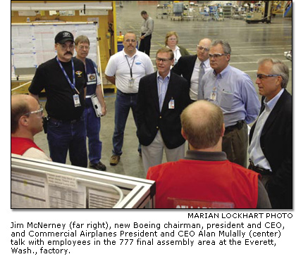 Jim McNerney and Alan Mulally talk with employees in the 777 final assembly area at the Everett, Wash., factory.