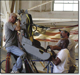 Phil Robles (left) David Flateau and Ken Kimbrough remove the ejection seat from a T-38A