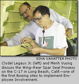 Clydel Legaux Jr. (left) and Menh Vuong discuss the Wing-Rear Spar Seal Process