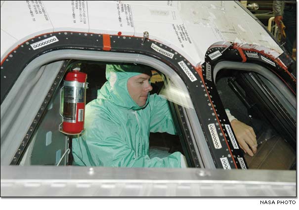 STS-114 Pilot James Kelly inspects the window in Space Shuttle Discoverys cockpit.