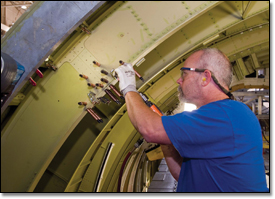 Thomas Barber drills out a frame splice on the C-17's center fuselage