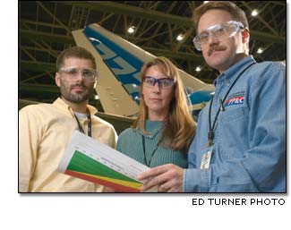 Tony Slama, Tonya Deines and Lowell Bergseid review the Integrated Program Schedule for the 777-200LR in the Everett, Wash., factory.