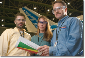 PP&C Project Management Specialists Tony Slama (left), Tonya Deines and Lowell Bergseid review the Integrated Program Schedule for the 777-200LR in the Everett, Wash., factory.