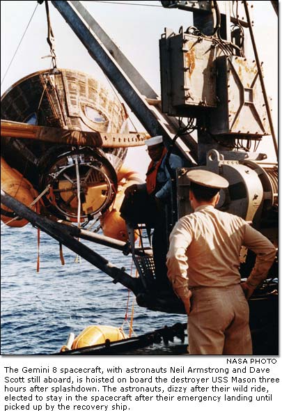 The Gemini 8 spacecraft, with astronauts Neil Armstrong and Dave Scott still aboard, is hoisted on board the destroyer USS Mason